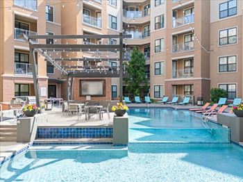 A large swimming pool in front of apartment buildings.